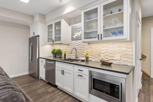 Lower level wet bar with refrigerator, microwave and dishwasher.
