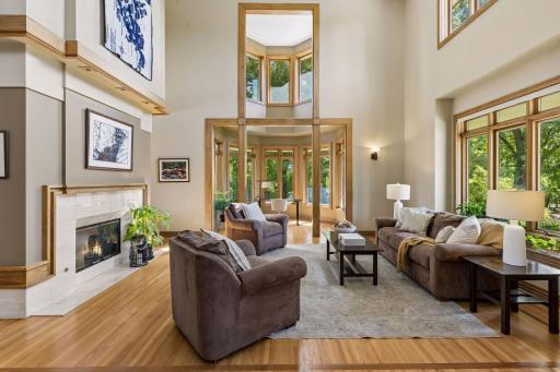 Soaring ceiling height and plenty of natural light in the main floor living room and office/sittingDramatic 20-foot ceilings and a gas fireplace create an impressive living space. area.