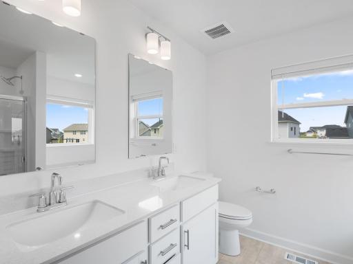 A glass-enclosed shower and nearby soaking tub provide daily escapes in the ownerâs bathroom
