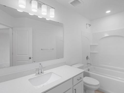 This full second-floor bathroom features a wide single vanity and shower-tub combination.