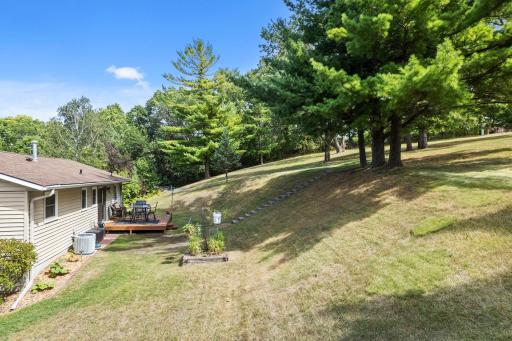Fabulous backyard setting featuring a picturesque hillside framed by serene, mature treesâoffering beautiful views, natural privacy, and a peaceful outdoor retreat. Steps to a future patio! It's dreamy and must see in person.