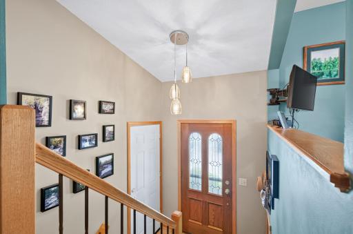 Bright entry with vaulted ceiling and modern lighting.
