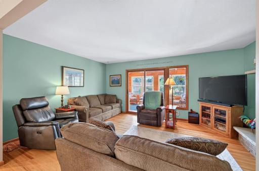 Bright upper-level living room with hardwood floors and access to the three-season porch.