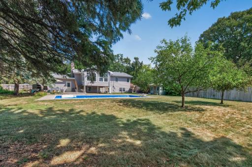 The backyard offers a wonderful combination of open lawn, shade and poolside recreation.