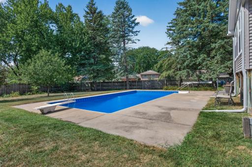 Sparkling in-ground pool surrounded by mature trees.