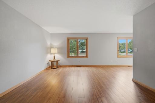 The large living room boasts luxury vinyl plank flooring, Anderson Renewal Windows and Blinds from Floor to Ceiling.