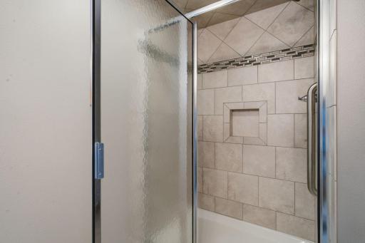 Beautiful tiled shower in the lower level bathroom as well - built in shelves and grab bars.