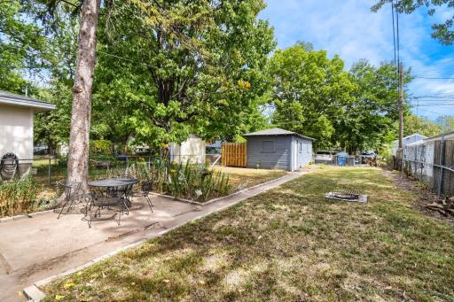 The fully fenced backyard features a patio area, fire pit area, room to play, and a one-car garage with charming carriage-style doors. With a dirt floor, the garage is well suited for parking, storage, or a variety of outdoor needs.