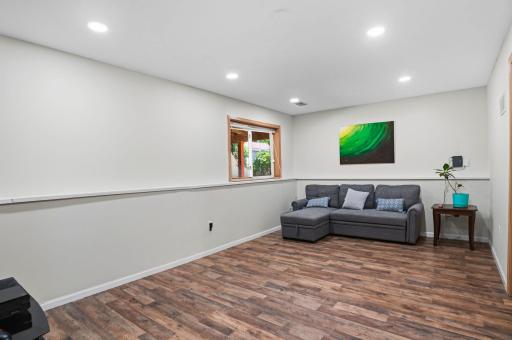 A spacious lower-level family room with updated flooring and recessed lighting, perfect for relaxing or entertaining.