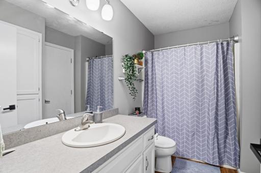 Private primary bathroom featuring a spacious vanity, full tub and shower, and ample storage.