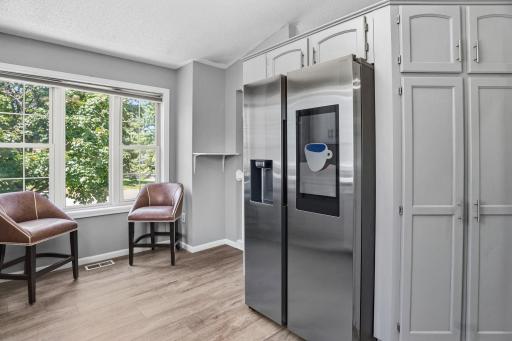 Sunlight fills the kitchen workspace, highlighting the counters, modern backsplash, and open connection to the living area.