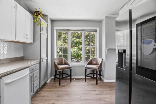 A charming breakfast nook surrounded by windows and peaceful views of the mature trees.