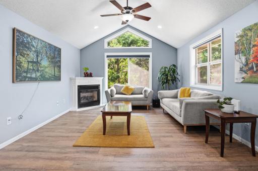 Vaulted ceilings, expansive windows, and a cozy fireplace make this living room bright and inviting.