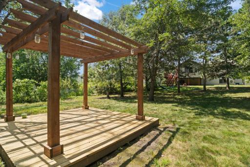 The backyard pergola overlooks the spacious, tree-filled yard and offers endless possibilities for outdoor enjoyment.