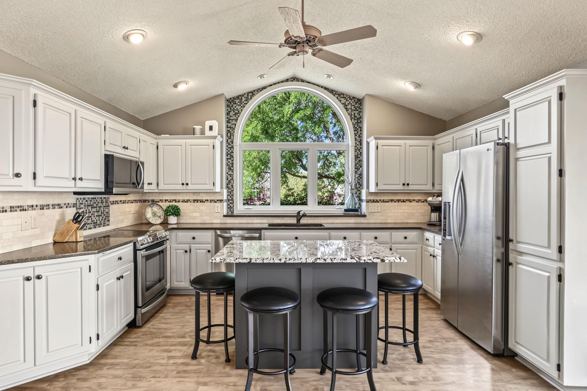 WOW! The kitchen is not only the heart of the home - it truly shines! The stunning custom arched window and beautiful tile surround create a gorgeous focal point, filling the space with natural light and character.