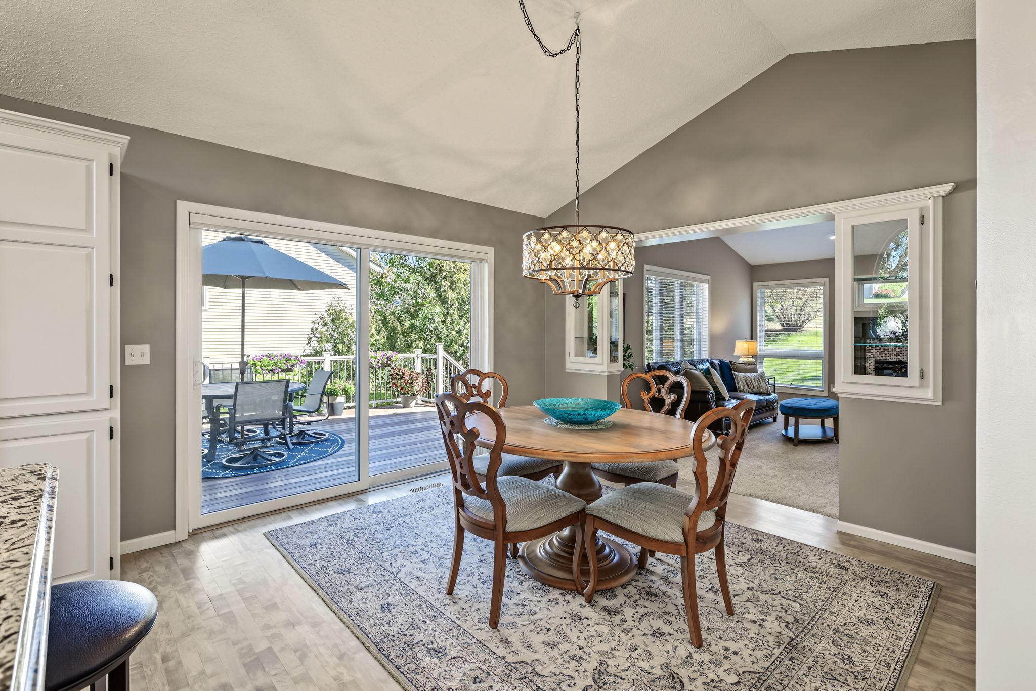Beautiful dining area with a vaulted ceiling and sliding glass doors that fill the space with natural light and open directly to the expansive deck, creating an effortless flow for indoor-outdoor entertaining.