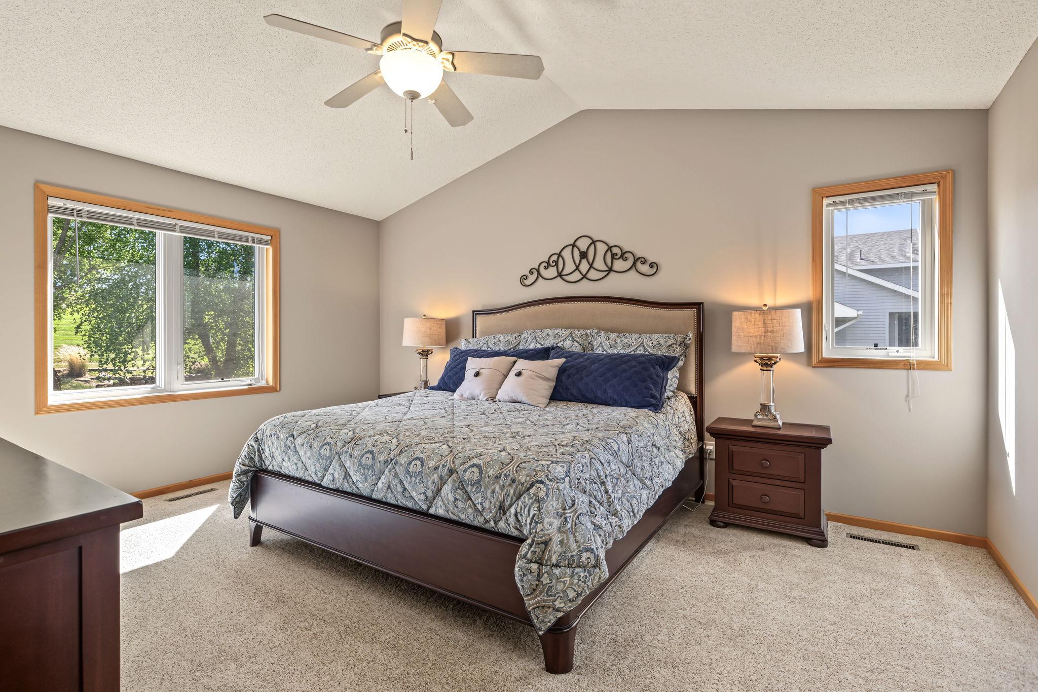 Spacious primary bedroom featuring a vaulted ceiling and ceiling fan, creating a comfortable retreat.