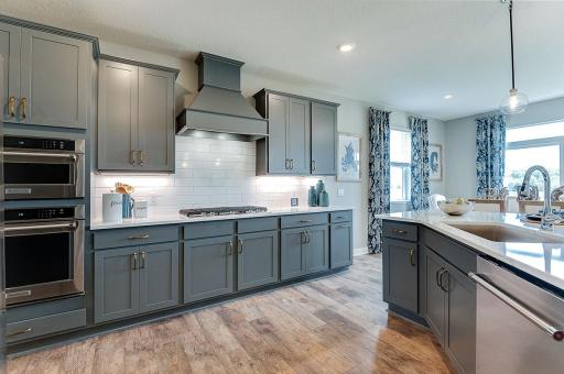 Chef central! KitchenAid 5 burner gas cooktop, microwave, oven, vented hood, dishwasher, and classic tile included. Photo of model, colors and finishes vary.