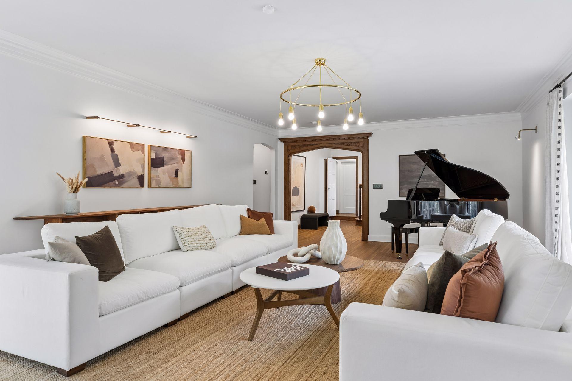 Inviting living room with a large seating area as well as space for a grand piano. Designer lighting.