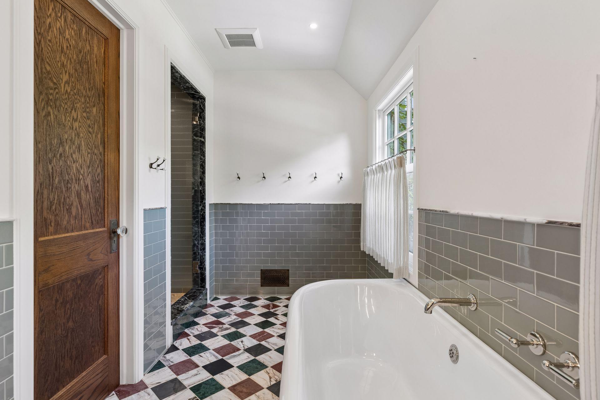 Primary bath featuring a private water closet, cast-iron soaking tub imported from London, and a spacious walk-in shower.