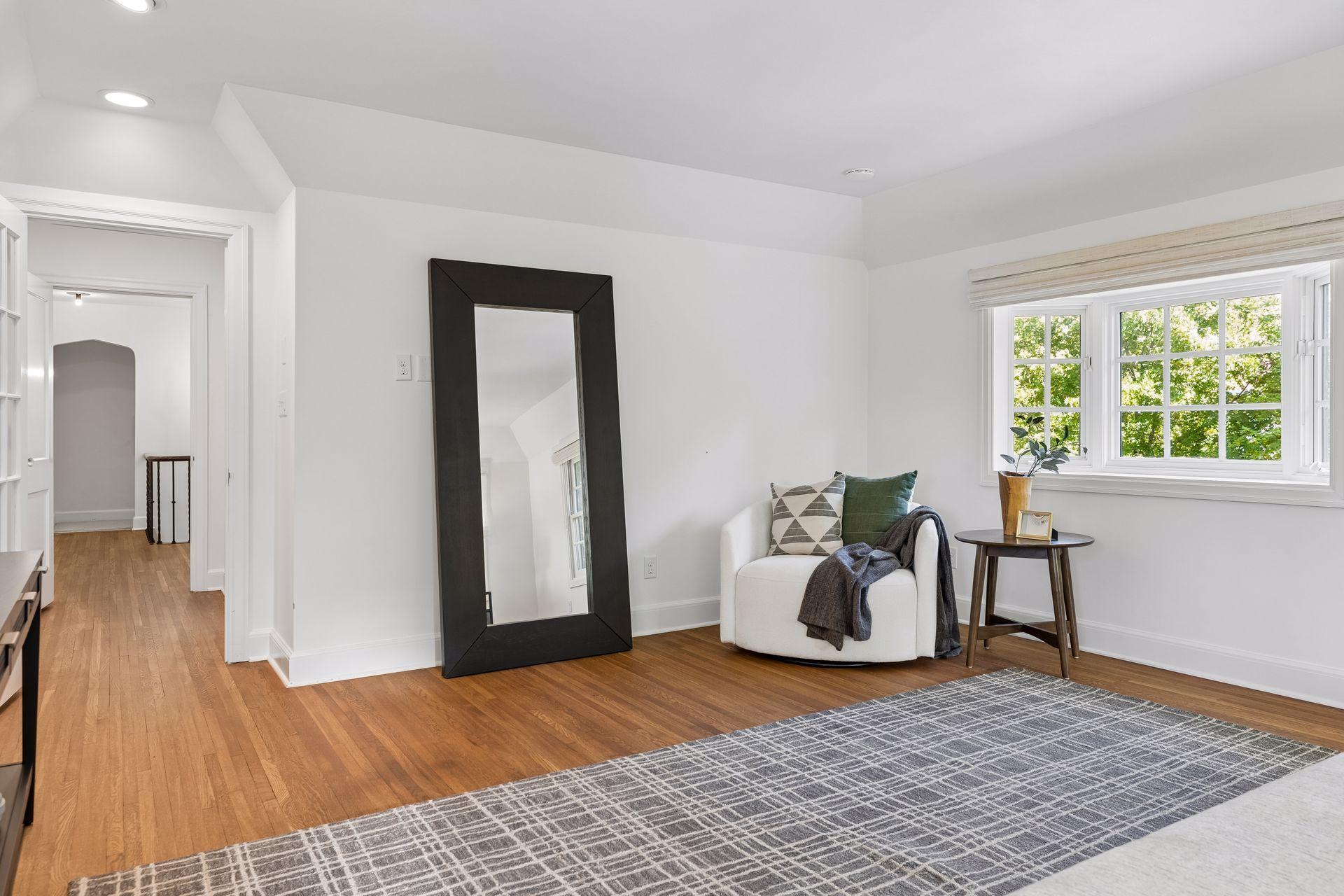 Primary bedroom with a door leading to an en suite hallway connecting the primary bath, walk-in closet, and sitting room with an office space.