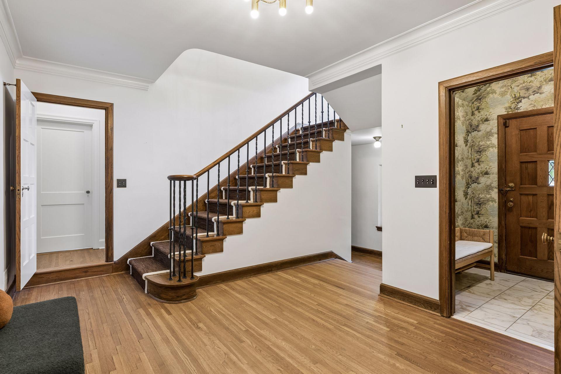 Returning to the front entry hall which leads to the original powder room with its own lounge area, a walk-in coat closet, and a stunning staircase leading to the bedroom levels.