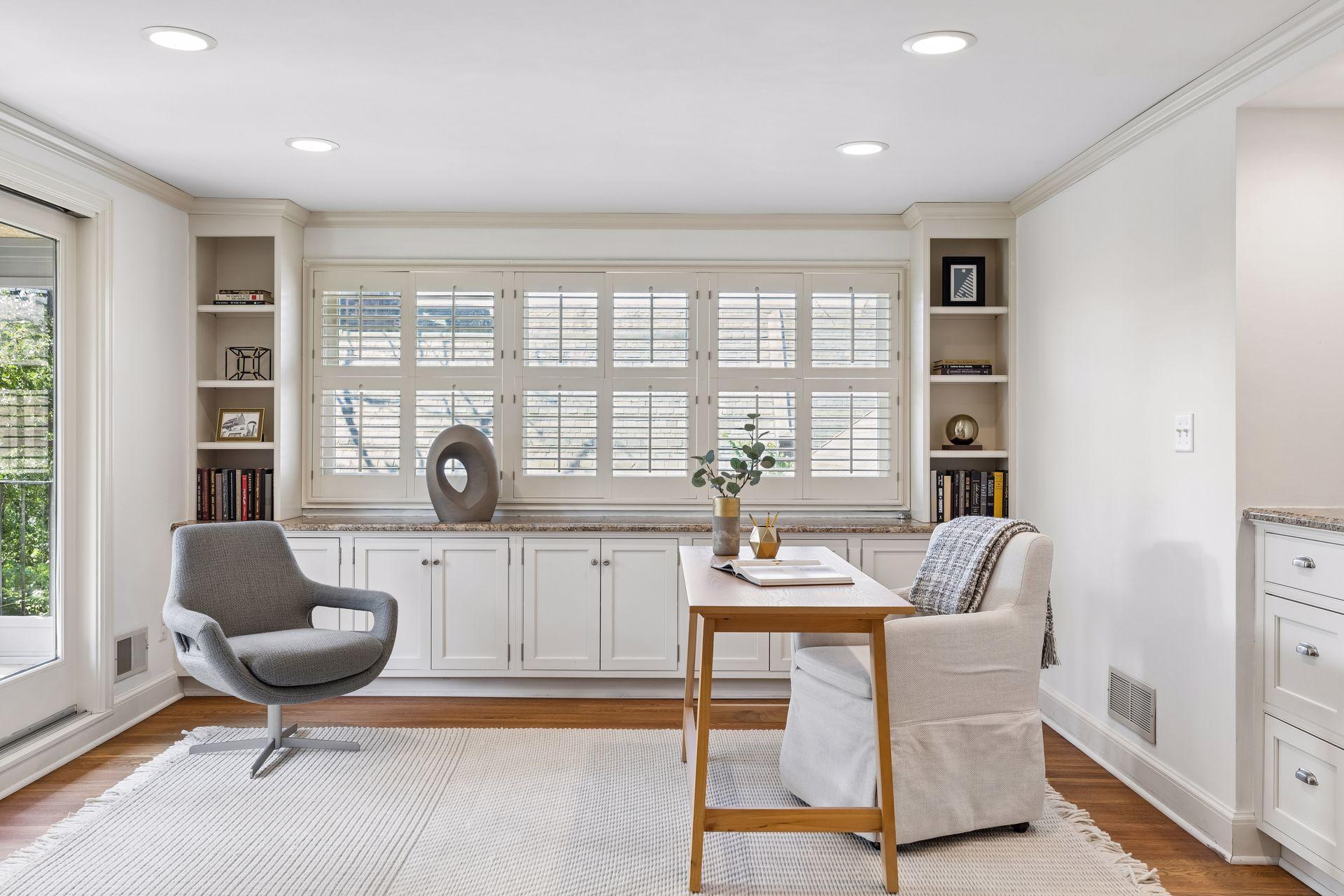 Upper level office area with built-in cabinets and library shelving. A three-season porch is accessible through a sliding door.