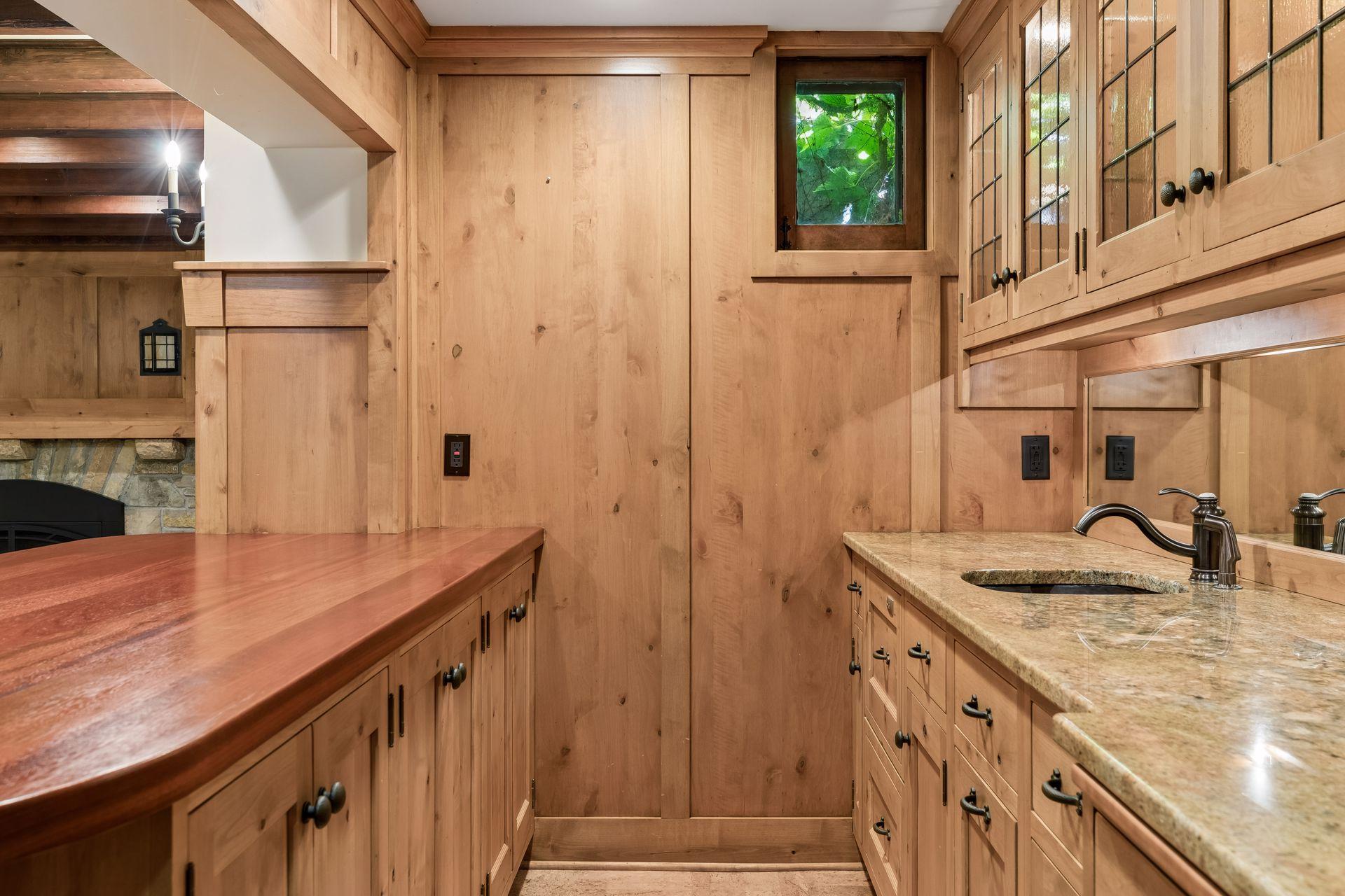 Lower level kitchenette and wet bar featuring a full refrigerator, a drawer dishwasher, wet bar, and lots of storage cabinetry.
