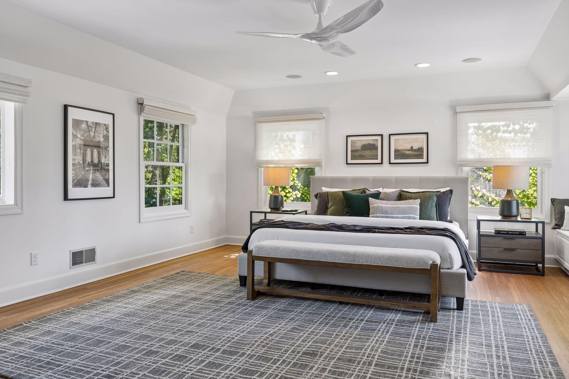 The spacious primary bedroom features electronic shades, a window seat overlooking the yard, east and south-facing windows, and lovely natural light.
