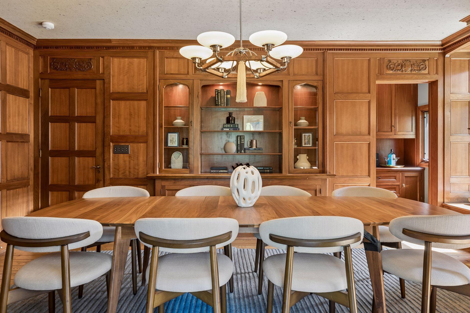 Gorgeous mahogany paneled formal dining room with separate butler's pantry, built-in cabinetry and shelving, fireplace, and a secret cabinet.