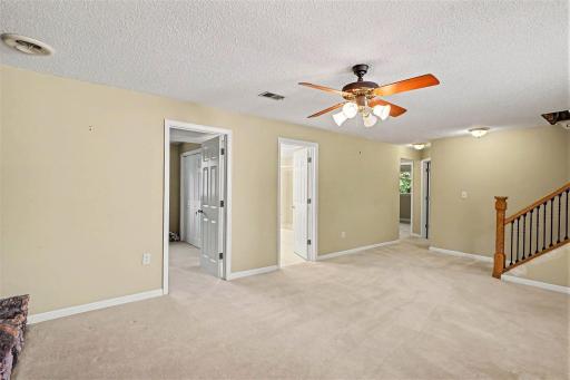 Lower level family room showing entry to bedroom. ,bathroom and hallway to 2 more bedrooms
