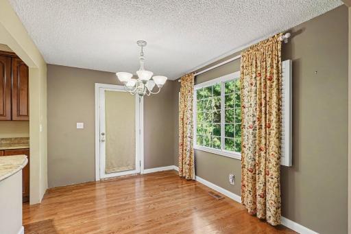 Dining area with window to front yard and door leading to side deck