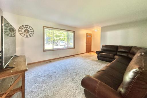 This angle of the living room reveals the front entry. Large front picture window brings in lots of natural lighting.