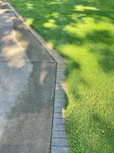 The brick boarder is a nice decorative enhancement to the concrete driveway.