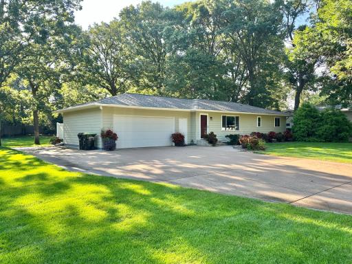 A huge concrete driveway greets you with a spacious extra parking space beside the garage.