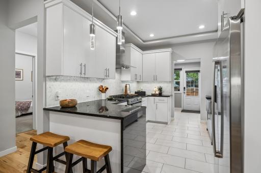 Updated kitchen featuring a waterfall countertop and breakfast bar, with plenty of space for casual meals and gathering.