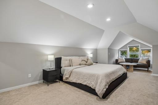 Spacious upper-level primary bedroom offering a private retreat with room for comfortable furnishings and a sitting area.