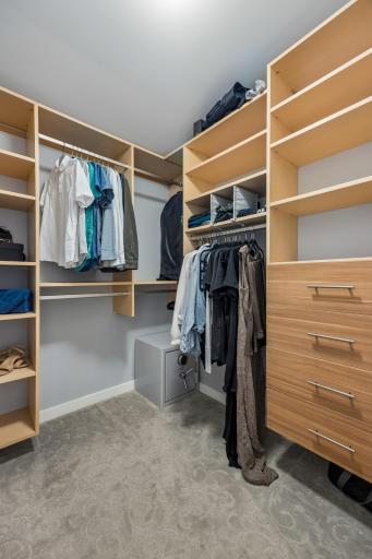 Spacious walk-in closet featuring custom California Closet organization for thoughtfully arranged storage.
