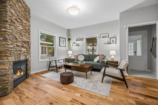 Spacious living room featuring a gas fireplace with a stacked stone surround, creating a warm and inviting focal point.
