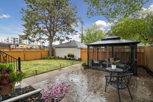 Backyard patio with a gazebo, creating a comfortable space for outdoor dining, relaxing, and entertaining.