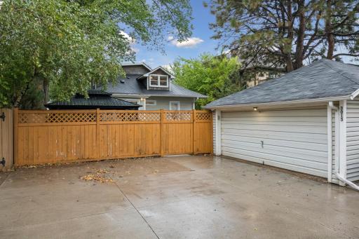 Detached two-car garage with an adjacent concrete parking pad for additional parking.