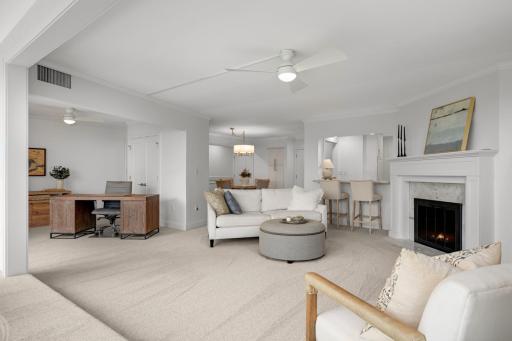 Open living room with ceiling fan, and electric fireplace.