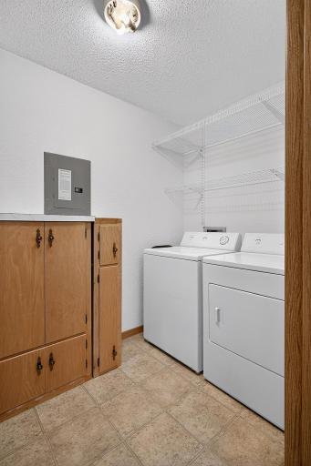 Spacious in-unit laundry room with built-in shelving and storage.