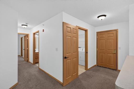 Front door, foyer and laundry room. Hallway to primary bedroom and bathrooms.