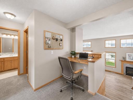 VIRTUAL STAGING! The built-in upper-level home office overlooks the dramatic two-story living room, creating an open, spacious workspace filled with natural light.