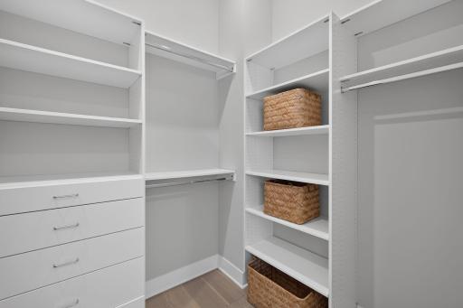 The primary custom walk-in closet offers exceptional shelving, hanging space and dedicated storage