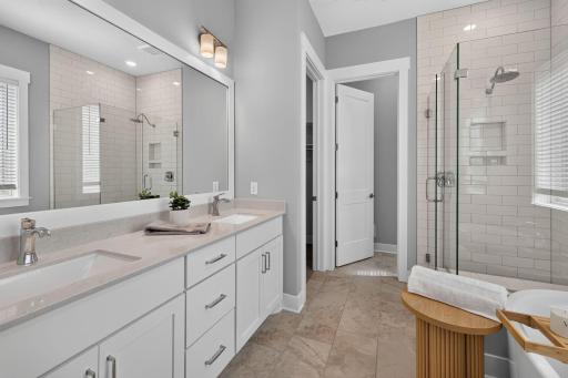 The primary bath feels like a spa retreat with dual sinks, walk-in shower, and large soaking tub
