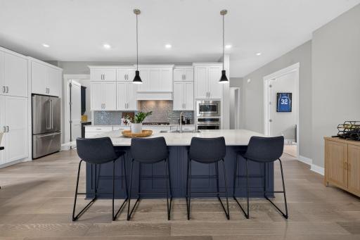 The spacious kitchen features an oversized island with generous seating and abundant cabinetry