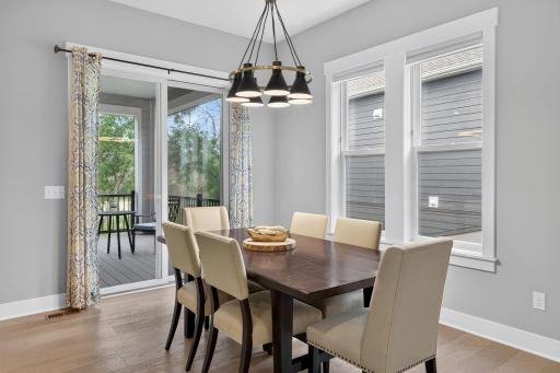 The bright dining area features large windows and convenient access to the screened porch