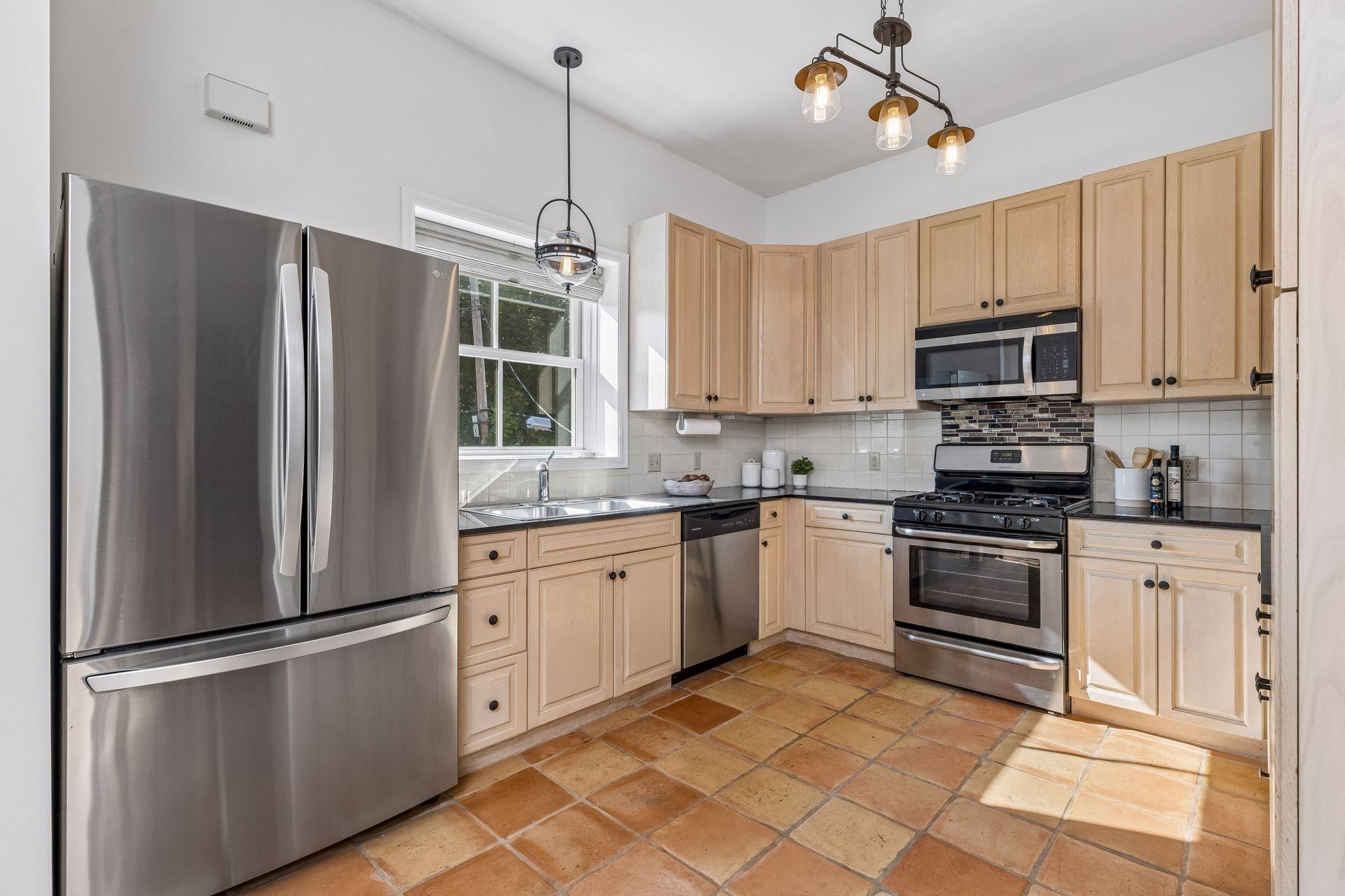 Large kitchen with newer appliances, gas range, and ample cabinets for storage.